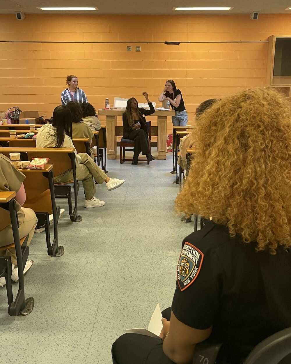 Author Ziwe Fumudoh raising her hand during a Rosebuds session at Rikers